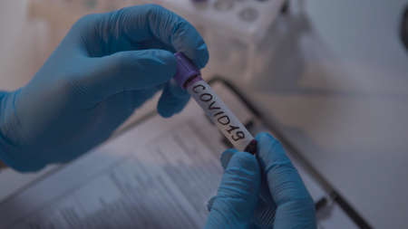 Doctor holding test tube with blood for 2019-nCoV analyzing. Coronavirus disease COVID-19 pandemic....
