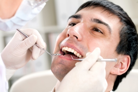 a man with an open mouth and dental mirrorの写真素材