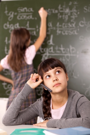 two girls on the background of the school boardの写真素材
