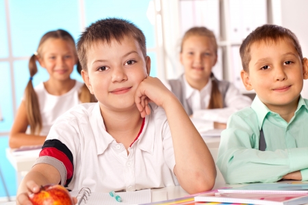 a group of four students at their desksの写真素材
