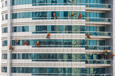 Team Of Climbing Workers Cleaning and washing windows service on high rise buildingの写真素材