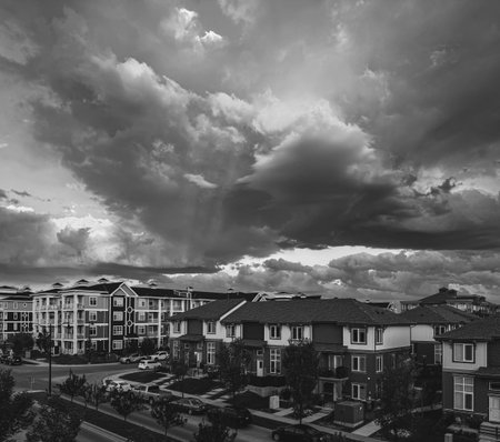 Striking black and white high-angle shot of a contemporary residential complex under a heavy, expressive sky. Perfect for editorial use, urban development, and moody background artの写真素材