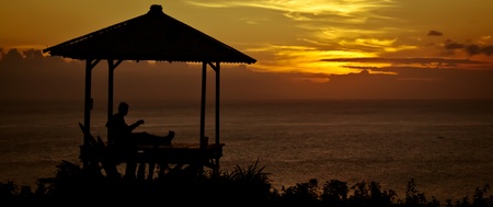 Guitarist playing music at sunset in Uluwatuの写真素材