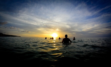 Surfers waiting at line up at sunsetの写真素材