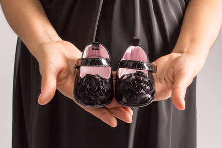 A cute pair of black shiny leather shoes for a baby girl as part of children apparel