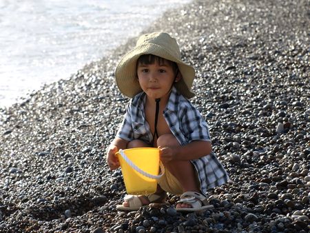 Little boy in hat on the beachの写真素材