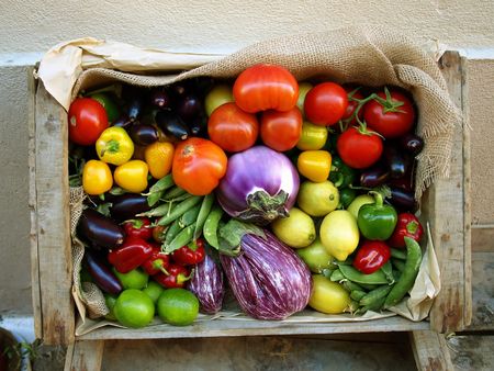 Just harvested fresh and ripe biological vegetables and fruits in a wooden box.の写真素材