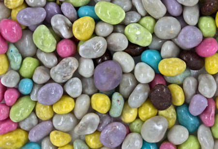Background of Colorful Sweet Candy Dragee like as stones on the sea.