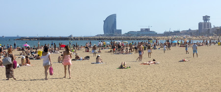 BARCELONA, SPAIN - JULY 4, 2015: A crowd of bathers in La Barceloneta Beach in Barcelona, Spain. This popular beach hosts about 500,000 visitors from everywhere during the summer season.のeditorial素材