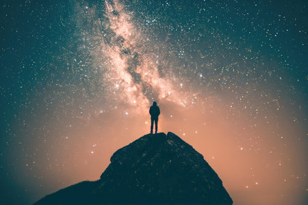 A silhouette of a person stargazing on a mountaintopの素材