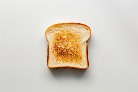 A golden-brown slice of toast on a bright white surfaceの素材