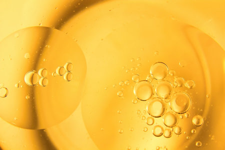 Yellow bubbles and drops of oil background, kitchen pattern, orange beverage background.の写真素材