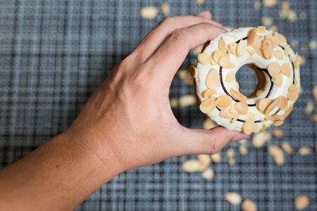 Man`s hand hold a White chocolate Donutの写真素材