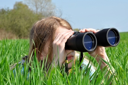 Girl looking through binocularsの写真素材
