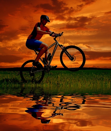 mountain biker silhouette in sunrise の写真素材