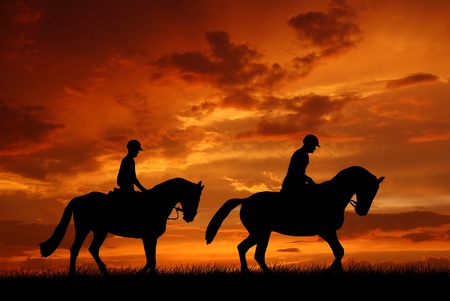 horse riders in the sunset の写真素材