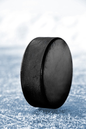 black hockey puck on ice rinkの写真素材