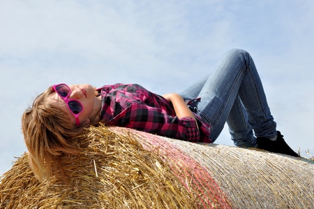 the girl lying on the straw bale の写真素材