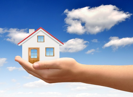 The house in hands on blue sky の写真素材
