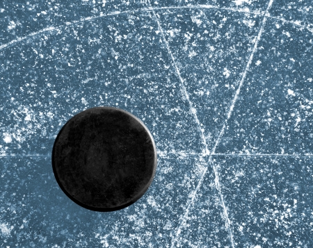 black hockey puck on ice rinkの写真素材