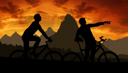 mountain bikers silhouette in sunsetの写真素材