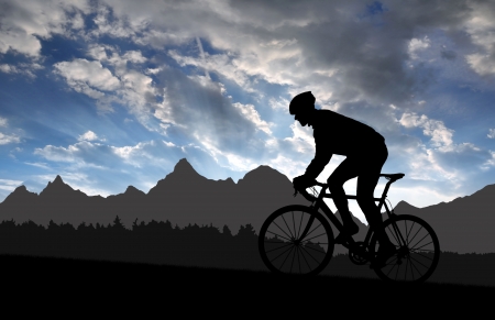 silhouette of the cyclist riding a road bike at sunsetの写真素材