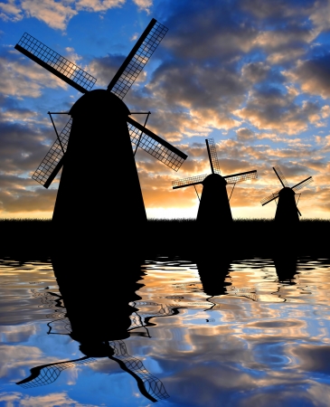 Silhouettes of windmills in the sunsetの写真素材