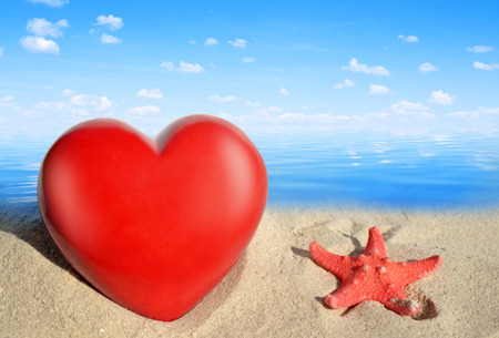 Starfish with heart on beachの写真素材