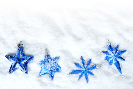 Blue christmas decorations in the shape star in snow