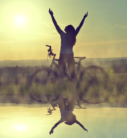 Girl on a bicycle in the sunsetの写真素材