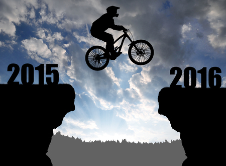 Silhouette cyclist jumping into the New Year 2016