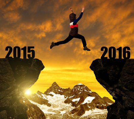 Girl jumps to the New Year 2016 at sunset. In the background Ober Gabelhorn - Pennine Alps,...