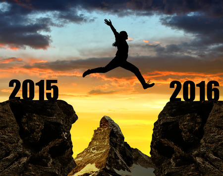 Girl jumps to the New Year 2016 at sunset. In the background Matterhorn - Pennine Alps, Switzerland.