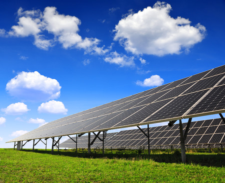 Solar panels against blue sky with clouds