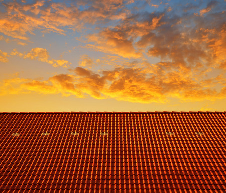 Roof house with tiled roof at sunsetの写真素材