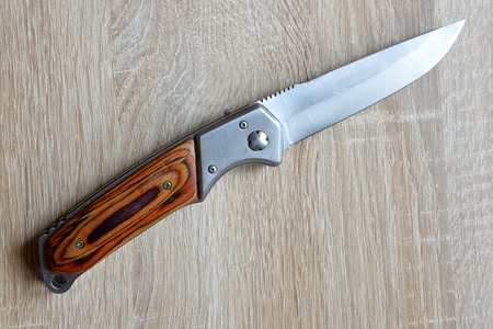 Pocket knife on the wooden desk