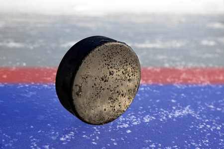Hockey puck lying on a ice rink.の写真素材