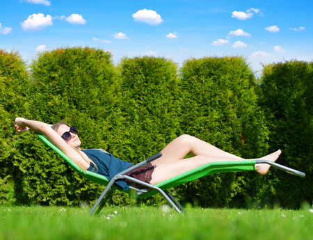 Woman relaxing on lounger in the garden.の写真素材