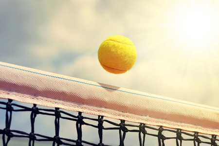 Tennis ball flying over the net.の写真素材