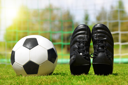 Soccer ball and shoes on football playground.の写真素材