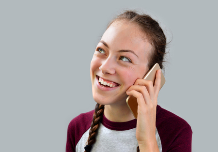Young girl with braids talk on mobile phone.の写真素材