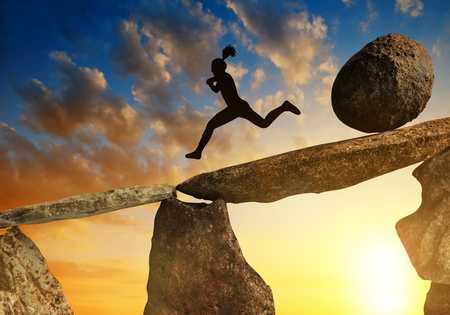 The tourist running away from big stone that is rolling down to him.の写真素材
