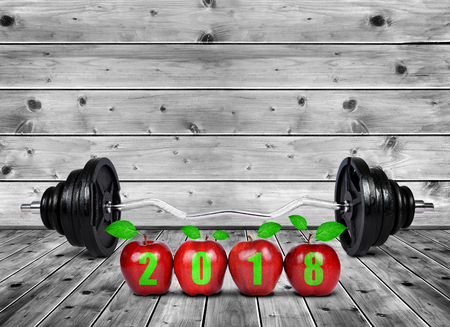 Red apples and large dumbbell on wooden planks. Healthy resolutions for the New Year 2018.の写真素材