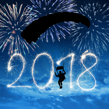 Silhouette skydiver parachutist landing in to the New Year 2018.