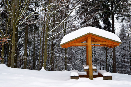 Snowy bench in winter landscape. National park Sumava in Czech Republic.の写真素材