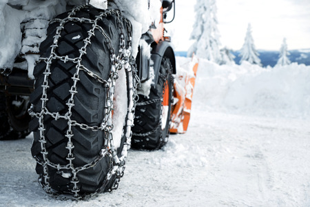Car wheels equipped with snow chains. Winter season.の写真素材