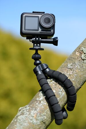 CHLUMCANY, CZECH REPUBLIC - JUNE 09, 2019: DJI Osmo Action in a protected case and a tripod on a branch of tree.のeditorial素材