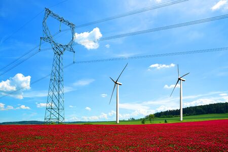 High voltage power lines with wind turbines in Crimson Clovers Field. Renewable Electric Energy...