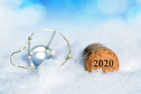 Cork Stopper of Champagne with Number 2020 in Snow. Happy New Year concept.