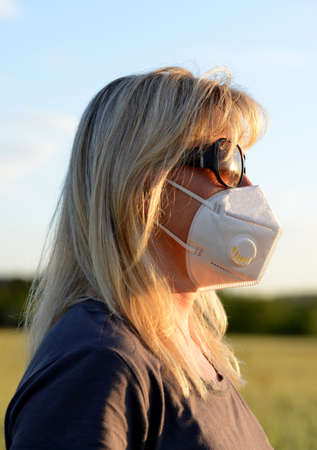 Woman in medical protective mask on her face. Life during covid-19 pandemic.の写真素材